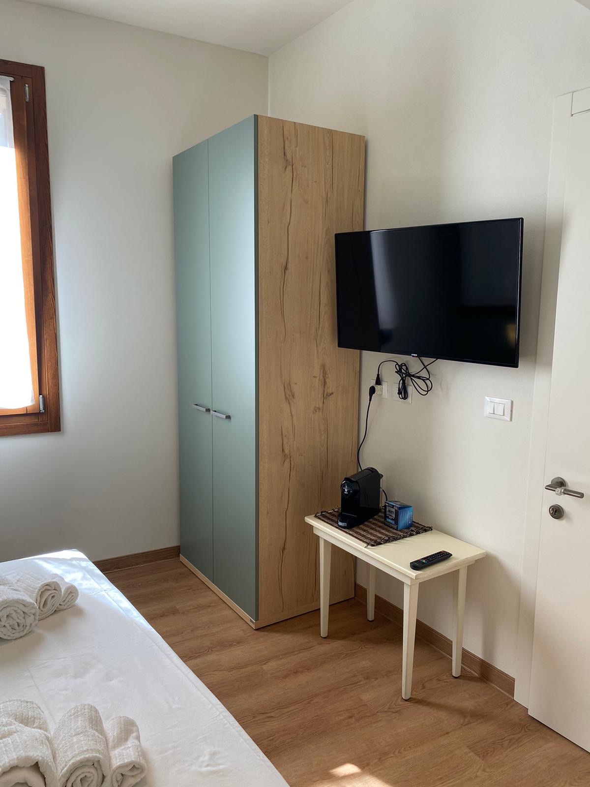 Camera con design sobrio e dettagli in legno chiaro, B&B Chioggia