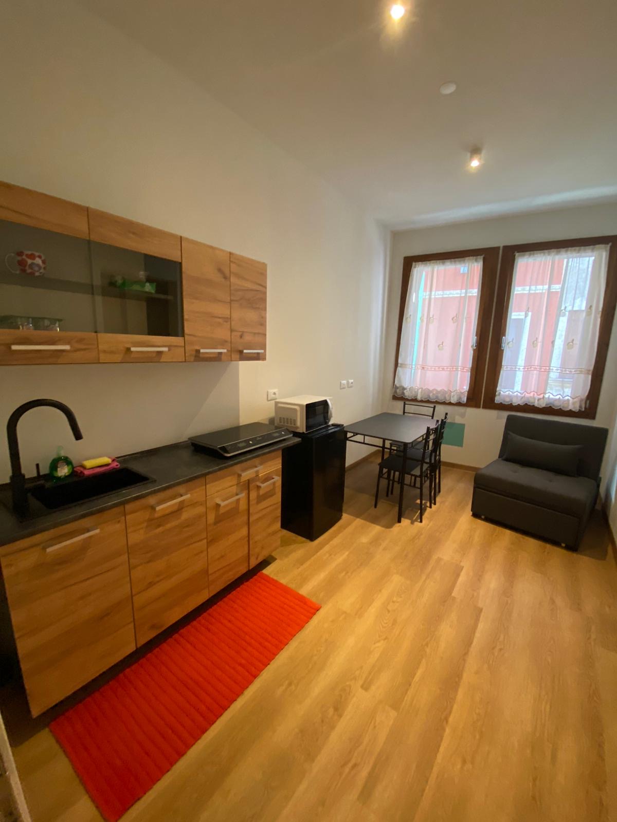 Interno bagno privato con piastrelle scure e inserti naturali