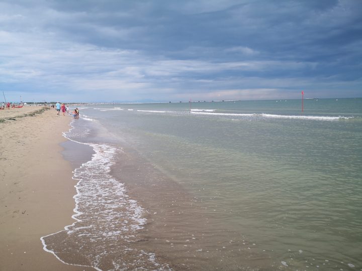 Turisti sulla spiaggia sabbiosa di Sottomarina